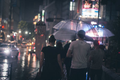 Rear view of people on street at night