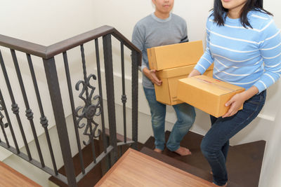 Woman standing on staircase at home