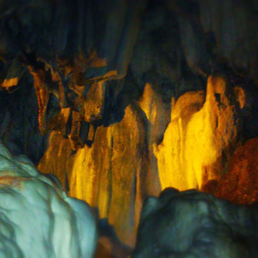 rock - object, rock formation, cave, nature, rock, beauty in nature, tranquility, geology, water, eroded, outdoors, orange color, yellow, scenics, tranquil scene, physical geography, no people, close-up, textured, non-urban scene