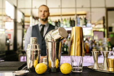 Kitchen utensils and lemons with bartender in background
