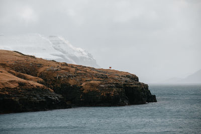 Scenic view of sea and mountains against sky