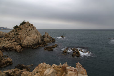 Scenic view of rocks in sea against sky