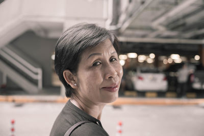 Close-up portrait of mature woman with short hair outdoors