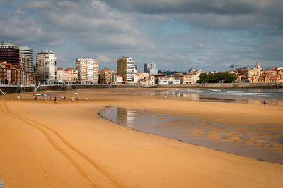 Sea and buildings against sky in city