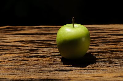 Close-up of apple on table against black background