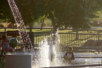 Water splashing on fountain against trees