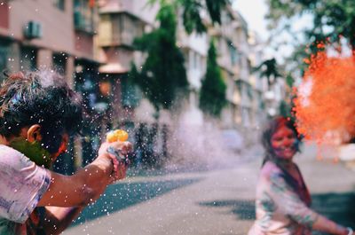 Reflection of man on multi colored umbrella