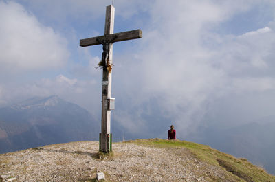 Close-up of cross on mountain against sky 