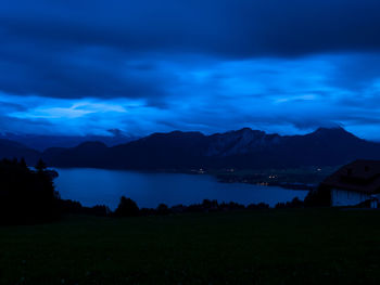 Scenic view of lake and mountains against sky at dusk