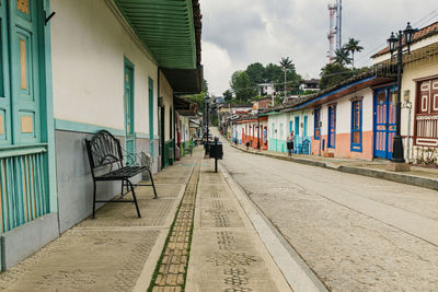 Empty road by buildings in city