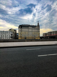 Buildings in city against cloudy sky