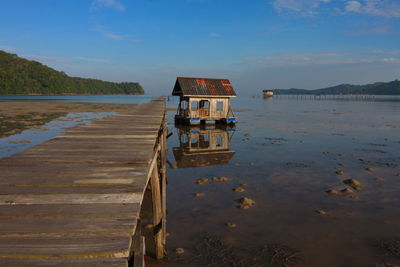 Lifeguard hut in lake against sky