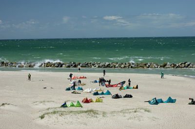 People at beach against sky