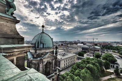 Buildings in city against cloudy sky