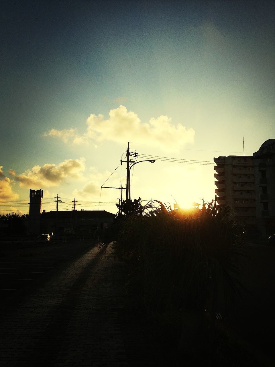 sunset, building exterior, architecture, built structure, silhouette, sky, sun, sunlight, orange color, road, city, street, transportation, electricity pylon, cloud - sky, outdoors, cloud, no people, building, nature