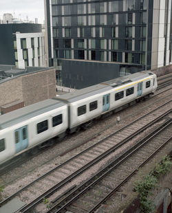 Train on railroad tracks in city against sky