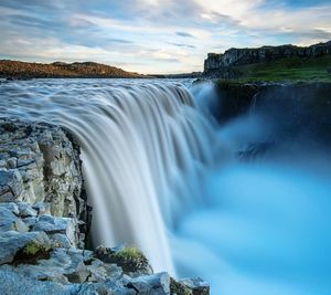 Scenic view of waterfall against sky