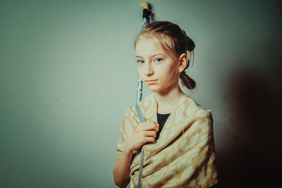 Portrait of young woman standing against white background