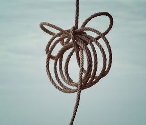 Close-up of rope tied against sky