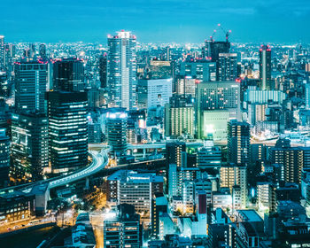 Illuminated cityscape against sky at night