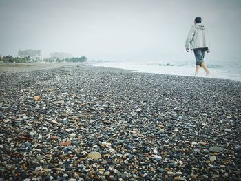 Rear view of woman standing on beach