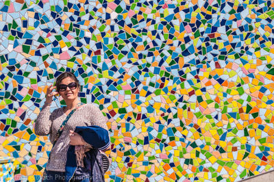 Portrait of smiling woman standing against wall