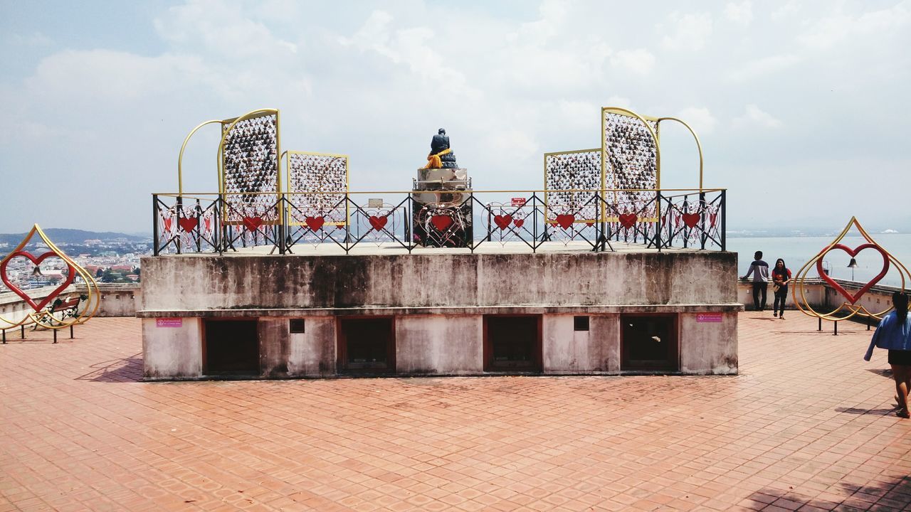 architecture, built structure, sky, building exterior, low angle view, cloud - sky, men, leisure activity, large group of people, lifestyles, person, day, cloud, outdoors, arts culture and entertainment, metal, famous place, amusement park, art and craft