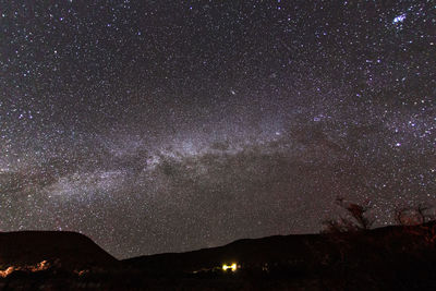 Low angle view of silhouette mountain against sky at night