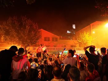 Group of people in front of buildings at night
