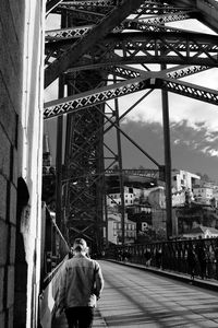 Rear view of people walking on bridge in city