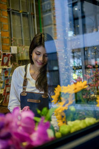 Young woman seen through store window