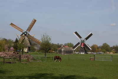 Traditional windmill on field against sky