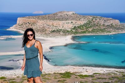 Full length portrait of young woman standing on beach