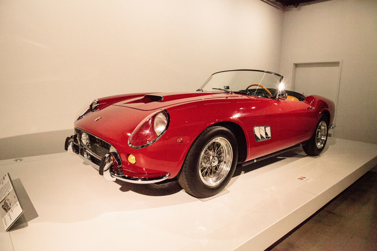 CLOSE-UP OF RED VINTAGE CAR ON MIRROR