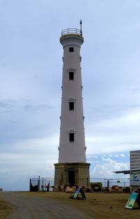 Lighthouse by sea against sky