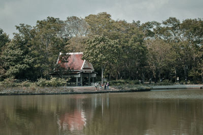 House by lake against sky