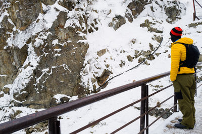 Man standing in the snow watching snow monkeys