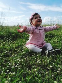 Full length of cute girl siting on field