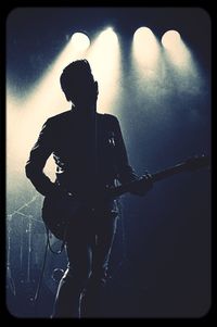 Silhouette man playing guitar