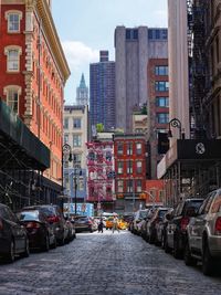 Street amidst buildings in city against sky