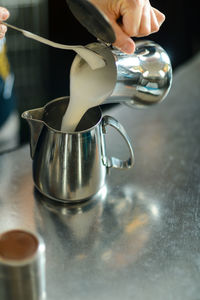 Hands of young adult caucasian female barista at work preparing