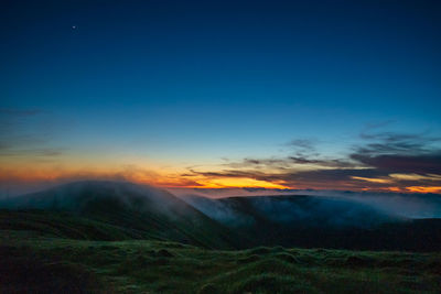 Scenic view of mountains against sky at sunset