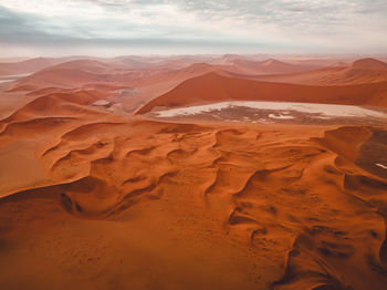 Scenic view of desert against cloudy sky