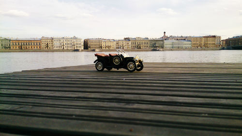 Motor scooter on river against buildings in city