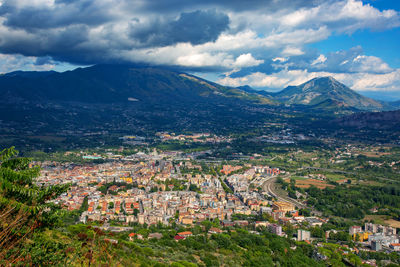 Aerial view of town against cloudy sky