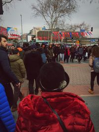 Rear view of people at concert against sky in city