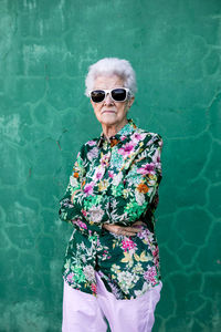 Woman wearing sunglasses standing against swimming pool