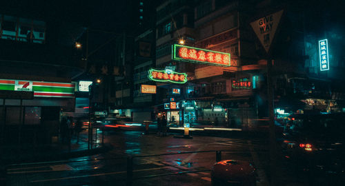 Illuminated city street and buildings at night