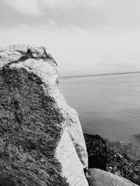 Scenic view of rocks by sea against sky