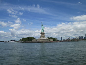 Statue of liberty by sea against sky